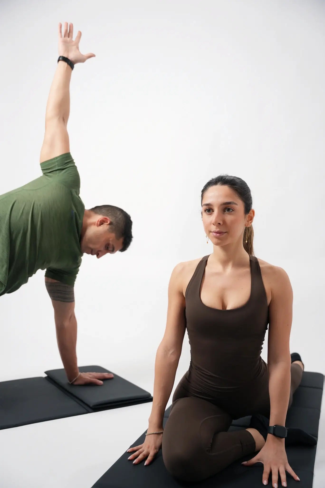 Two people practicing yoga on a white background
